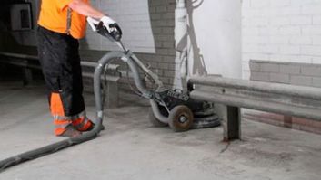 Työntekijä käsittelee betonilattiaa